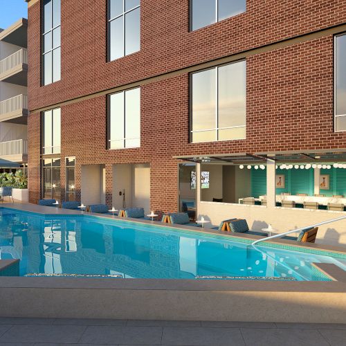 The image shows an outdoor pool at a modern building, with lounge chairs, a bar area, and large windows reflecting the sky.