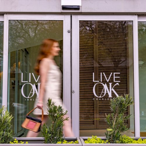 A couple stands at a doorway, with a cat perched on the right side, looking in; a small child in the middle, all framed by three panels.