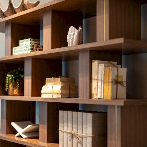 A cozy wooden bookshelf filled with books, decorative items, and a few plants.