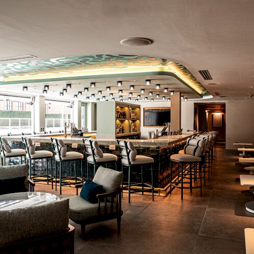 A cozy restaurant or cafe with warm lighting, tables and chairs, a bar or counter area, and people dining inside, creating a inviting atmosphere.